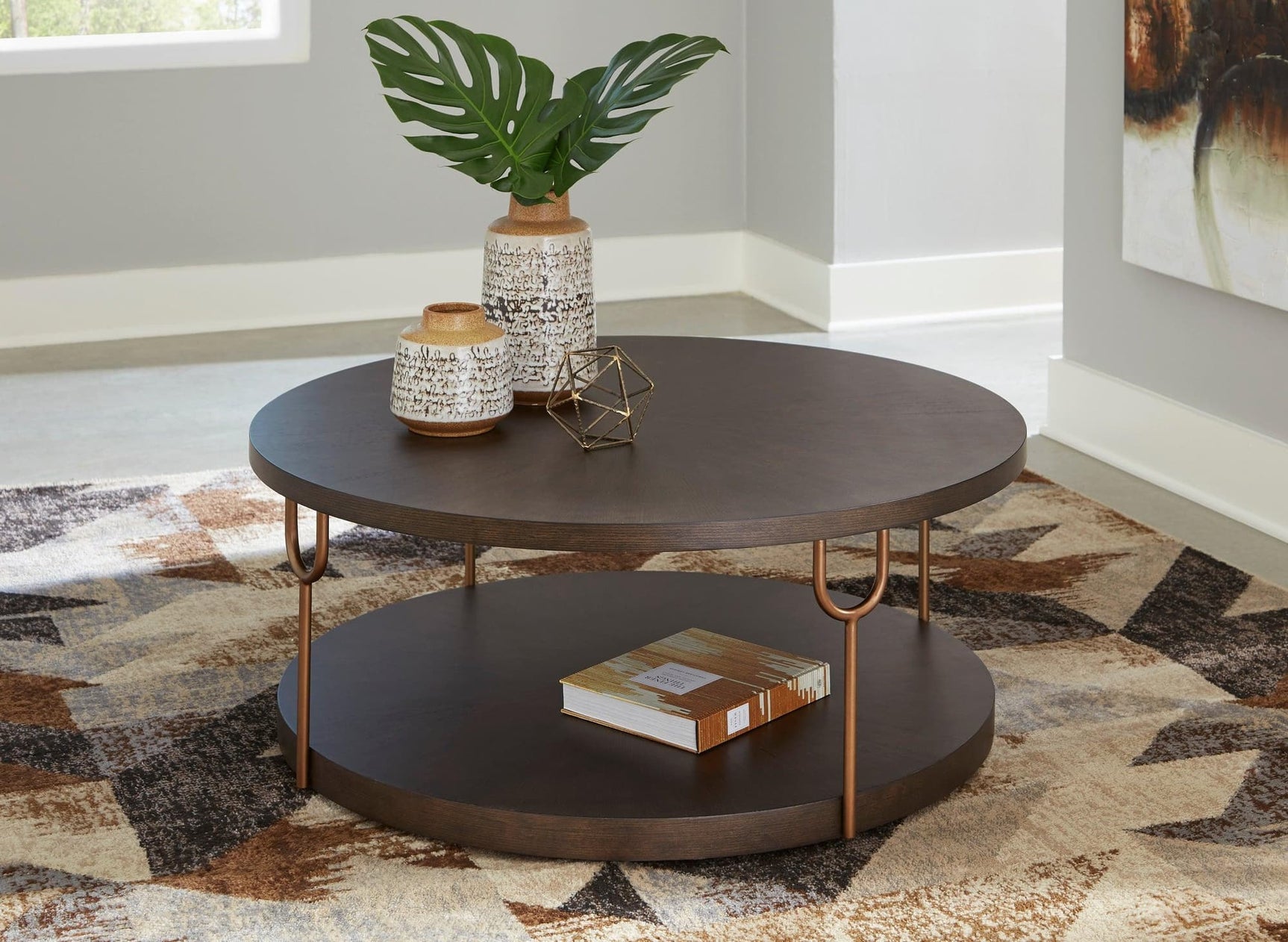 Hugh round dark brown cocktail table with antiqued goldtone tubular legs front view