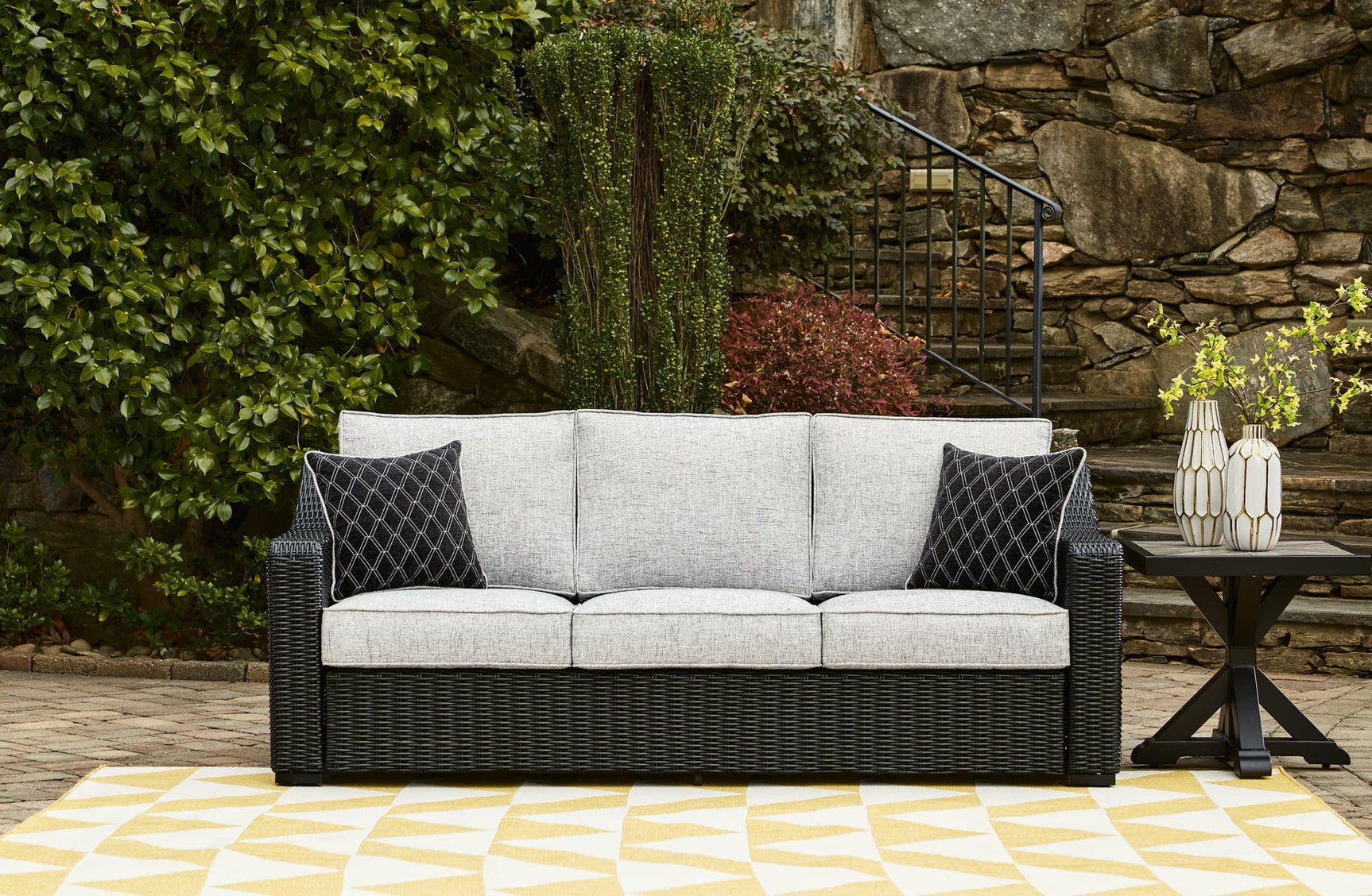 Beachcroft outdoor sofa black frame with light gray cushions, angled side view
