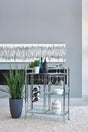 Derion chrome serving cart front view with glass shelves and caster wheels