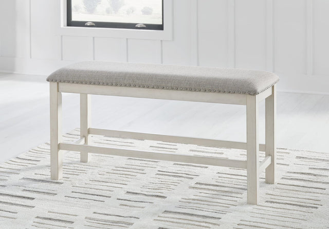 Robbinsdale antique white 49-inch counter height dining bench with light gray upholstered cushion, angled view