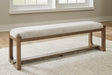 Front angle of Cabalynn 63-inch dining bench with oatmeal upholstery and light brown wood base