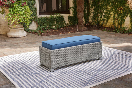 Naples Beach Outdoor Bench angled view showing light gray resin wicker and blue cushion