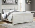 Front angle view of Robbinsdale Antique White King Panel Bed showing carved headboard