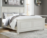 Front angle view of Robbinsdale Antique White King Panel Bed showing carved headboard