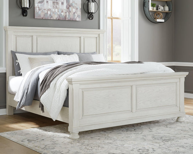 Front angle view of Robbinsdale Antique White King Panel Bed showing carved headboard