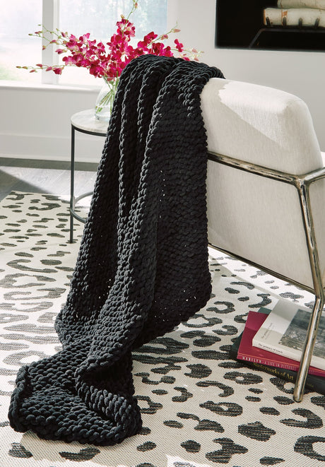 Chaddon black throw blanket draped on sofa