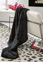 Chaddon black throw blanket draped on sofa