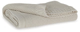 Gayelery Sand Cotton Throw folded on wooden surface