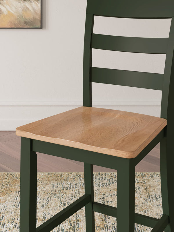 Gesthaven dining set showing natural wood table with green accents and two matching barstools