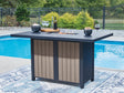 East Beach outdoor bar table in navy blue with driftwood finish, fire pit lit, front angle