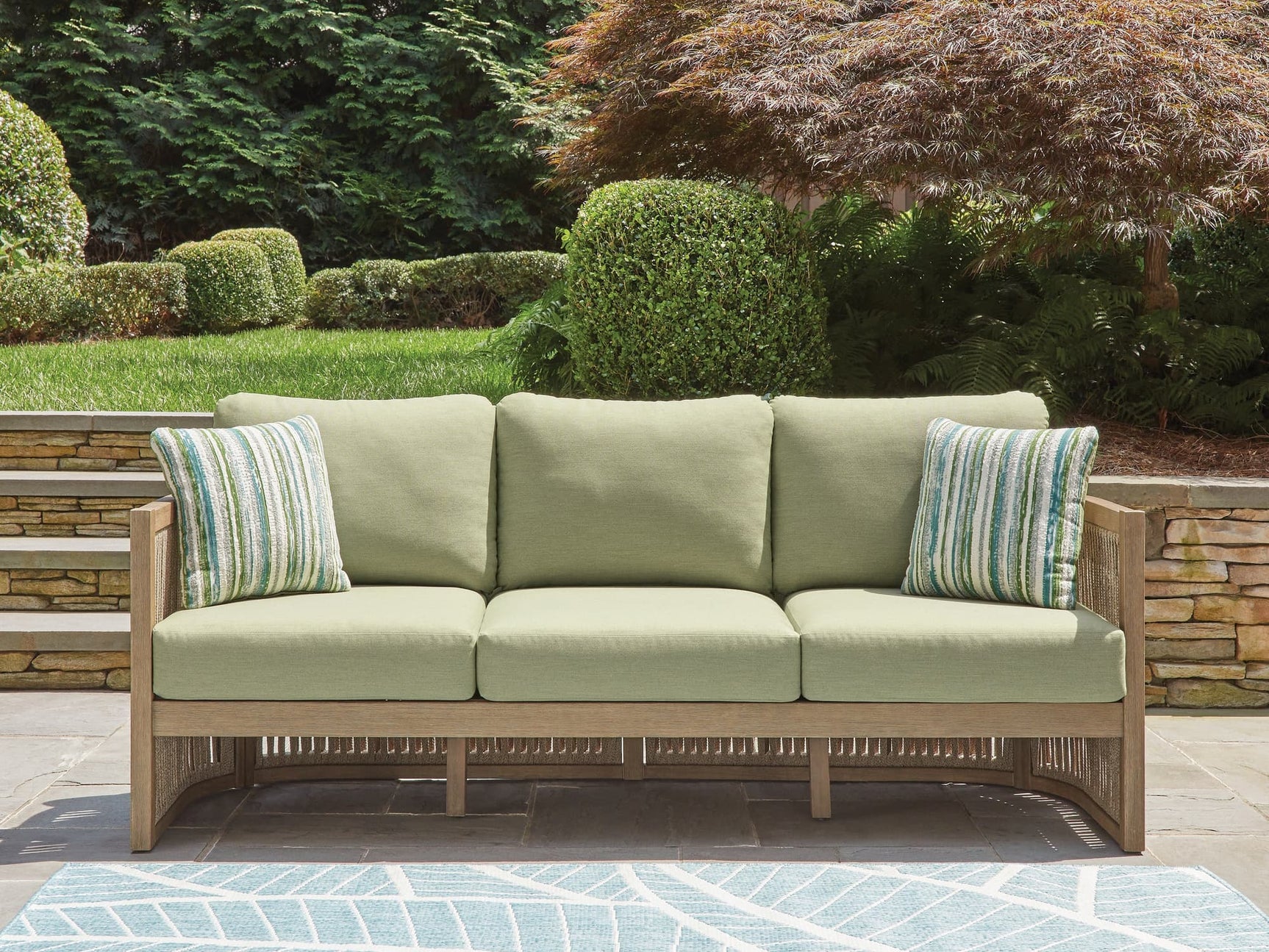 Serena Shores beige and green outdoor sofa with cushions front view