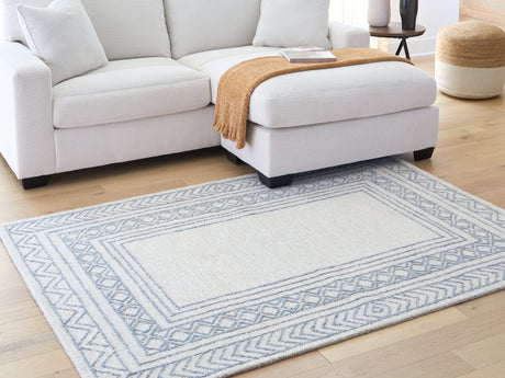 Azelhurst 5x7 area rug showing blue, ivory, and gray geometric bordered pattern