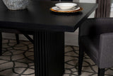 Black wood dining table in styled dining room setting