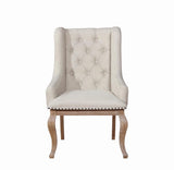 Close-up of diamond button tufting and nailhead trim on armchair back