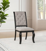 Side angle of Phelps upholstered dining chair showing distressed noir rubberwood legs