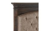 Close-up of tufted panel and nailhead details on bed