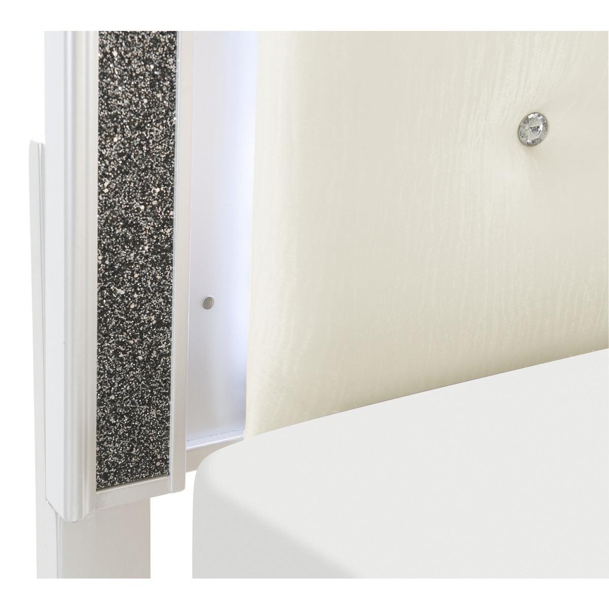 Close-up of button-tufted white faux leather headboard with LED lighting
