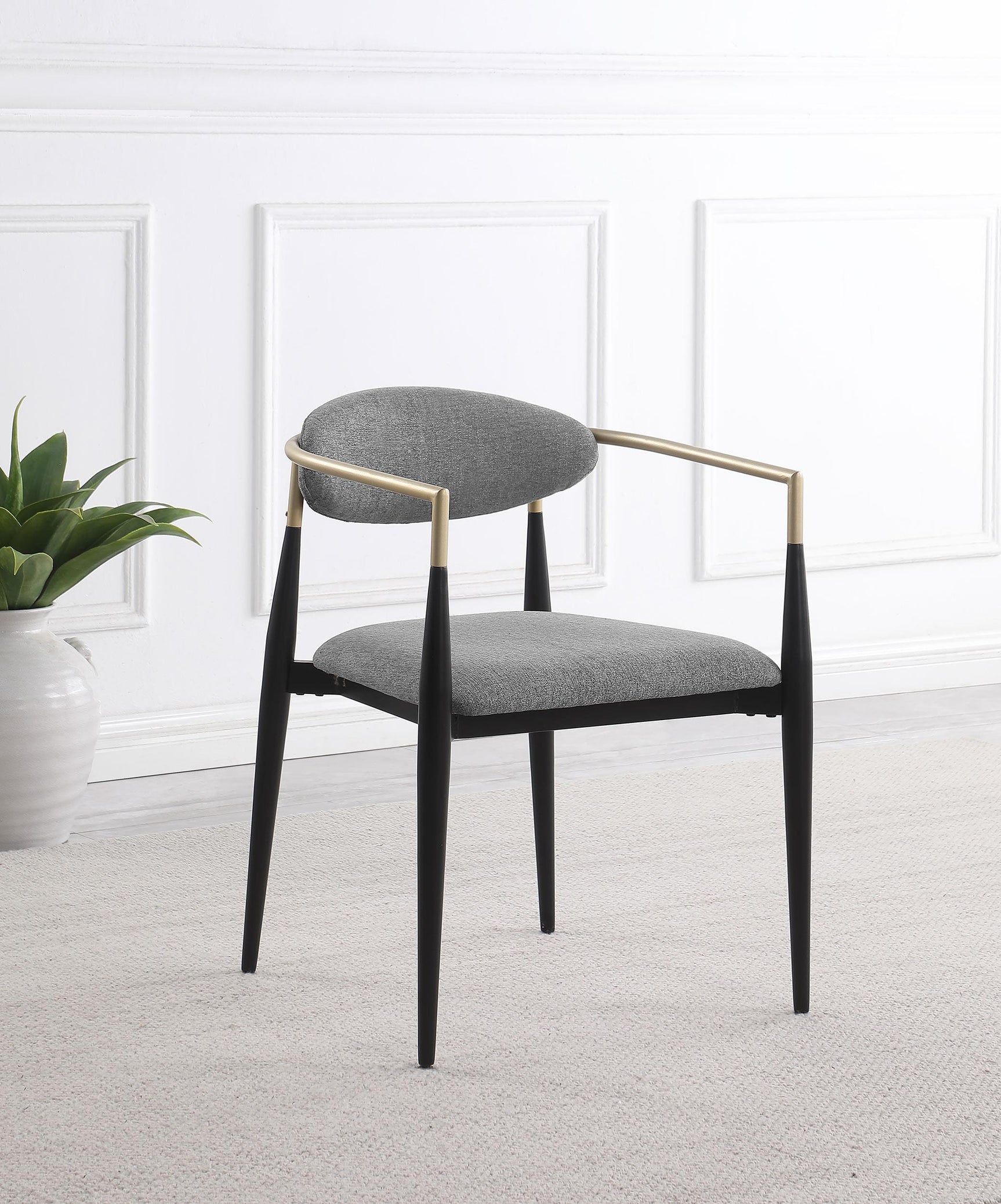 Alexis dining arm chair, side view showing black metal frame and hand-painted gold armrests