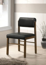 Side view of Kehoe black leatherette dining side chair showing curved backrest