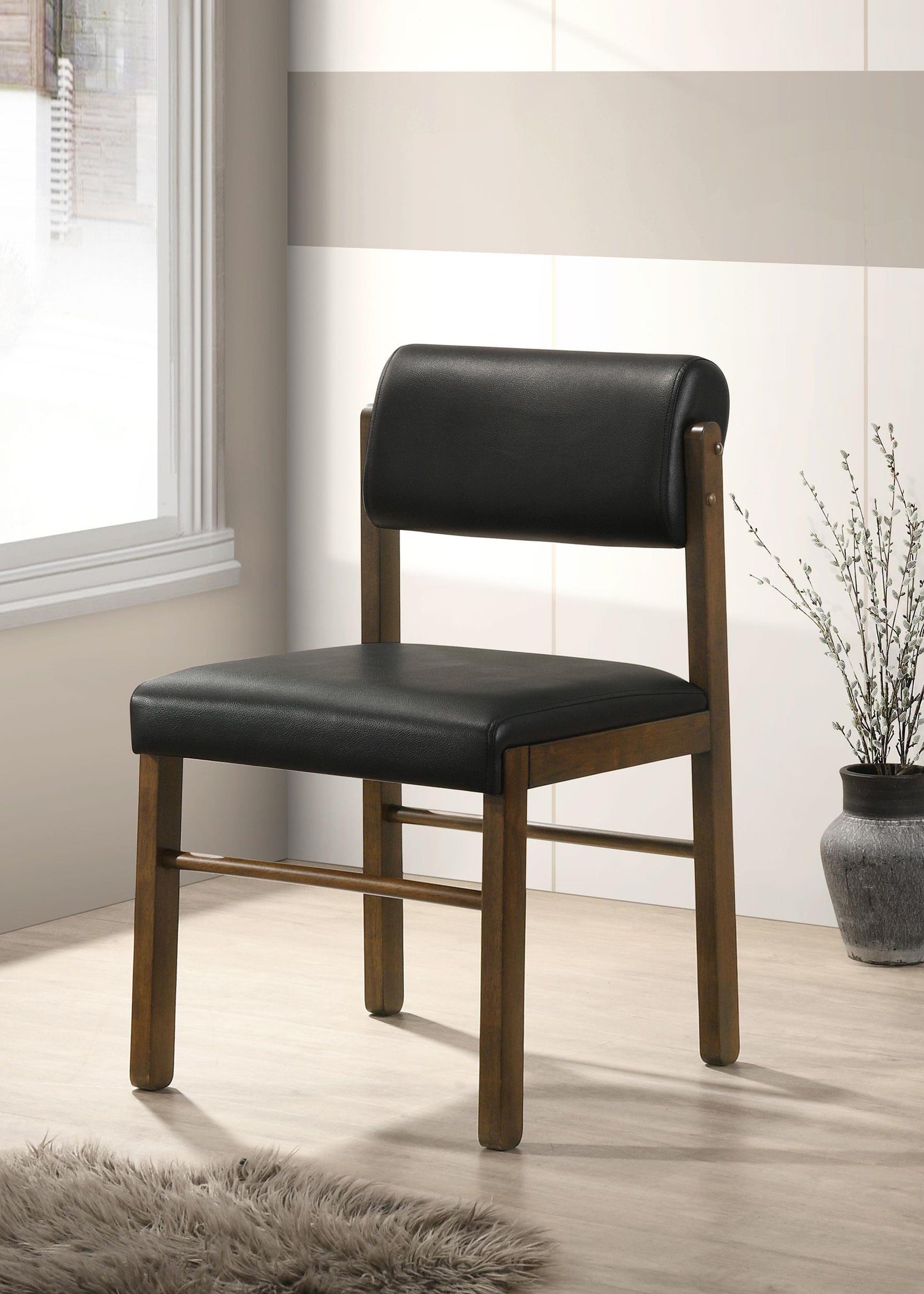 Side view of Kehoe black leatherette dining side chair showing curved backrest