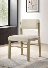 Side angle of Kehoe upholstered dining side chair with cream fabric