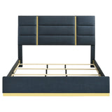 Gold base detail on footboard of navy upholstered queen bed