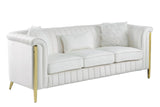 Close-up detail of cream velvet upholstery and gold legs on living room set