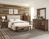 Close-up of button tufted beige headboard with nailhead trim