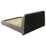 Rounded side rails of taupe upholstered platform bed