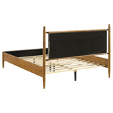 View of bed footboard and side rails in light brown wood
