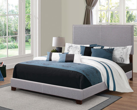 Boyd King Upholstered Bed showing black solid wood legs and nailhead trim, side angle