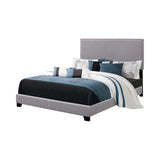 Boyd Queen Upholstered Bed side angle highlighting black solid wood legs and chrome nailhead detailing