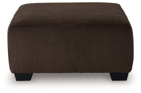 Close-up of chocolate velvet upholstery and exposed faux wood feet