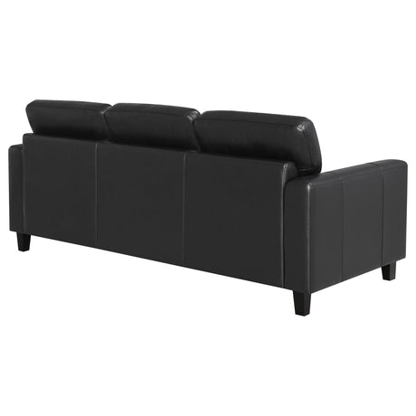 Detailed view of sofa track arm in black faux leather