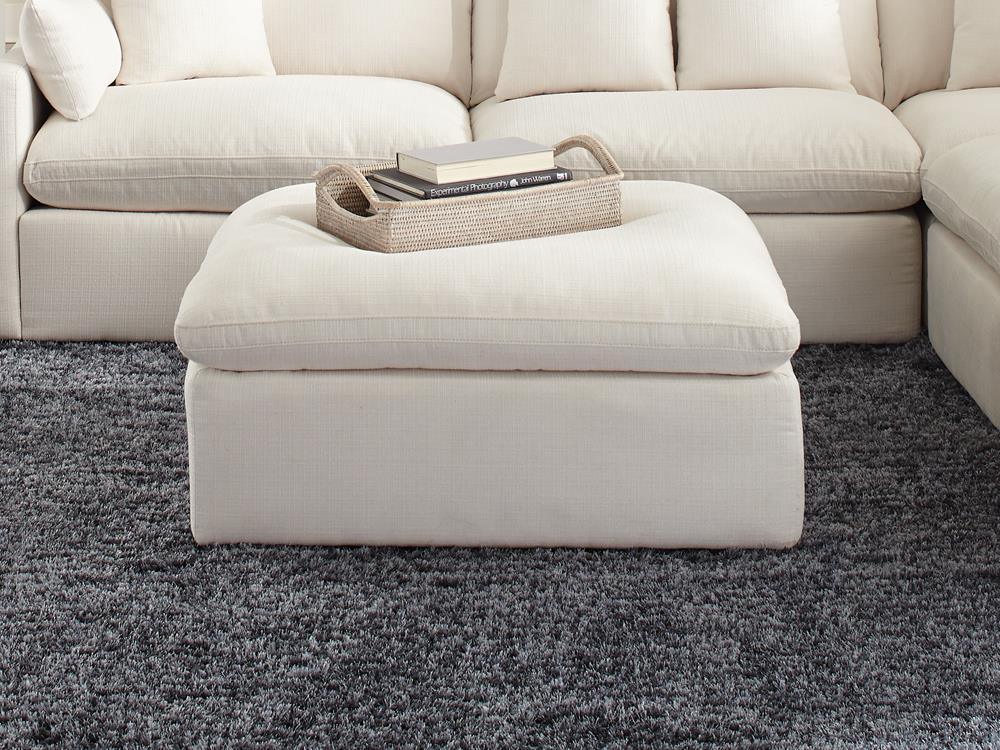 Hobson off-white upholstered ottoman with tufted cushion seat, angled front view