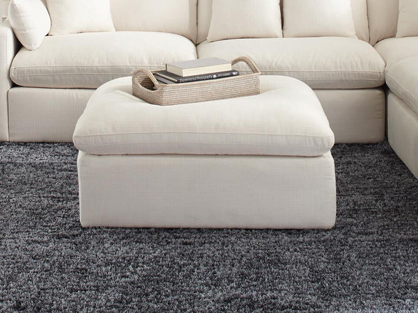 Hobson off-white upholstered ottoman with tufted cushion seat, angled front view
