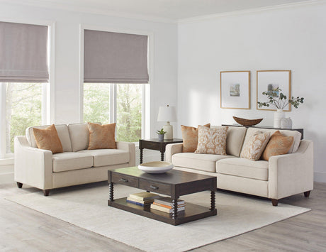 Back angle of Christine beige loveseat highlighting tapered legs and fabric texture