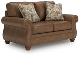 Close-up of nailhead trim and faux leather upholstery on loveseat arm