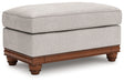Clearbrooke Ottoman angled view showing chenille fabric and decorative legs