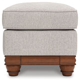 Clearbrooke Ottoman side view showcasing turned faux wood legs