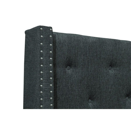 Close-up detail of button tufting and nailhead trim on headboard