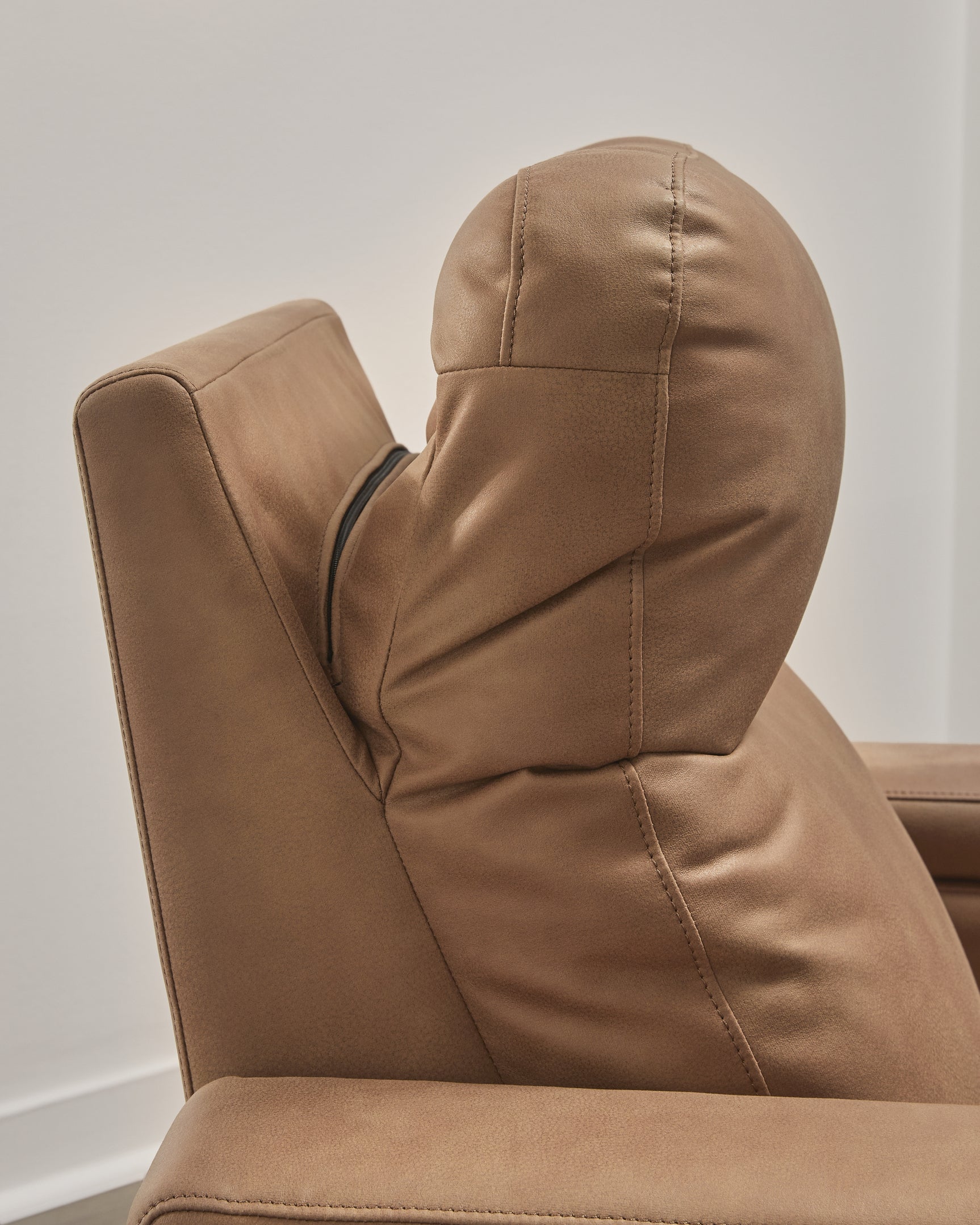 Close-up side view showing headrest adjustment on Lorrenton caramel faux leather power glider recliner