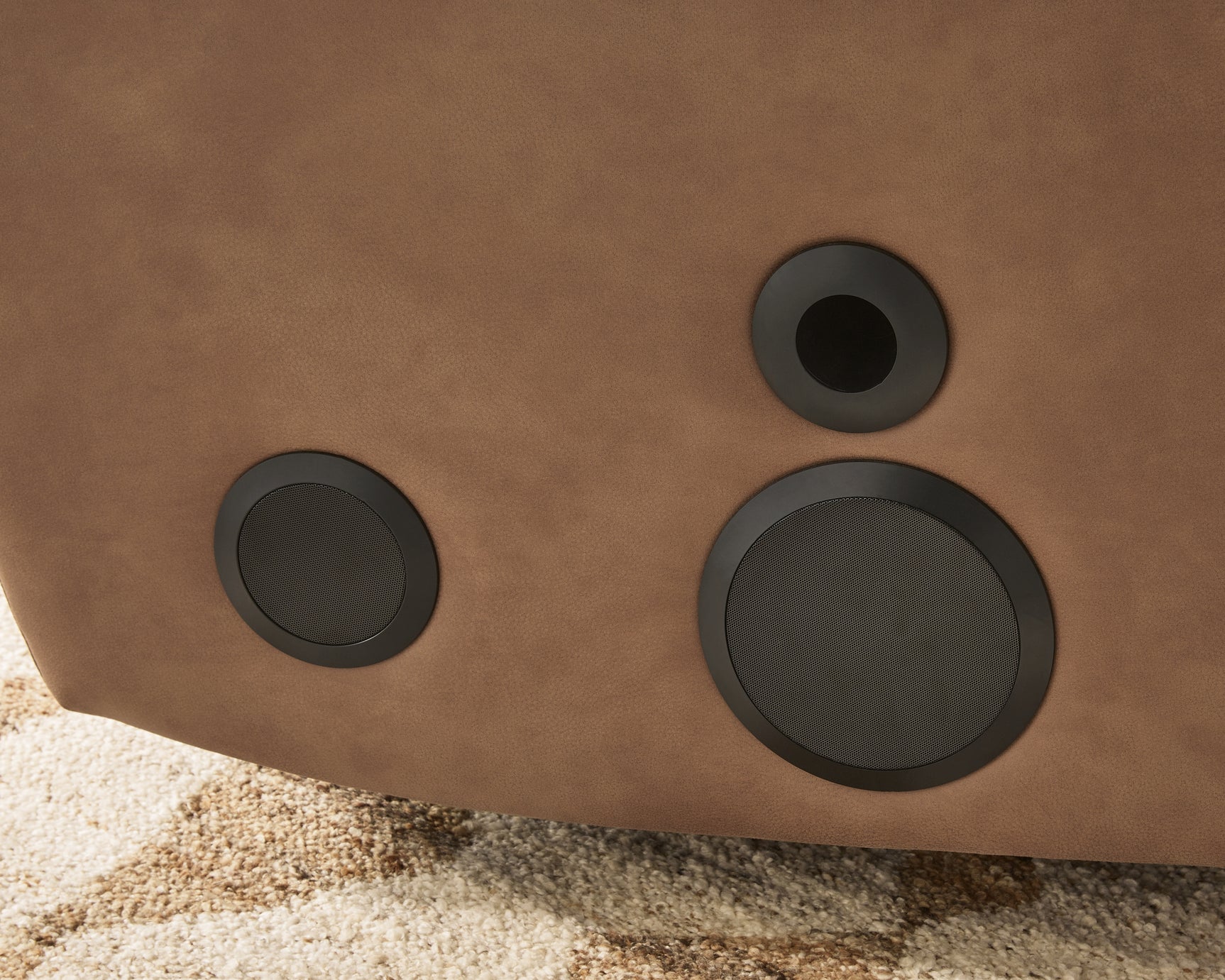 Speaker detail on Lorrenton caramel faux leather power glider recliner