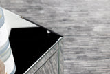 Coquette mirrored accent table styled with decor on shelves