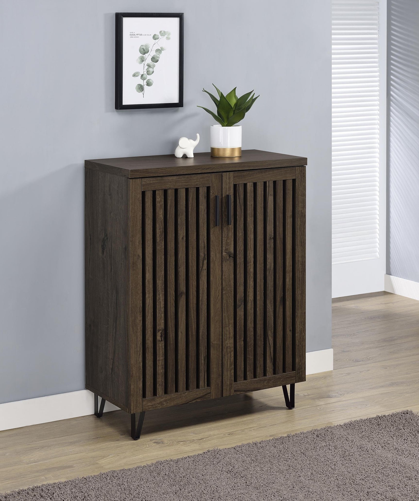 Side angle of Brixton shoe cabinet showing vertical slatted doors and metal legs