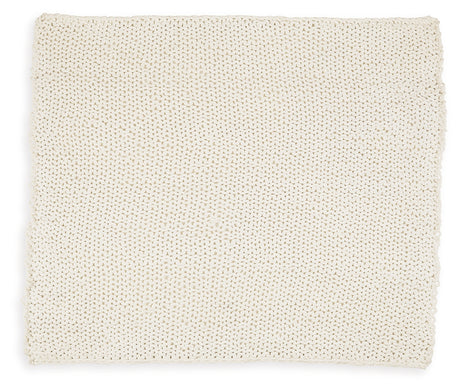 Close-up of hand-knitted texture on ivory throw