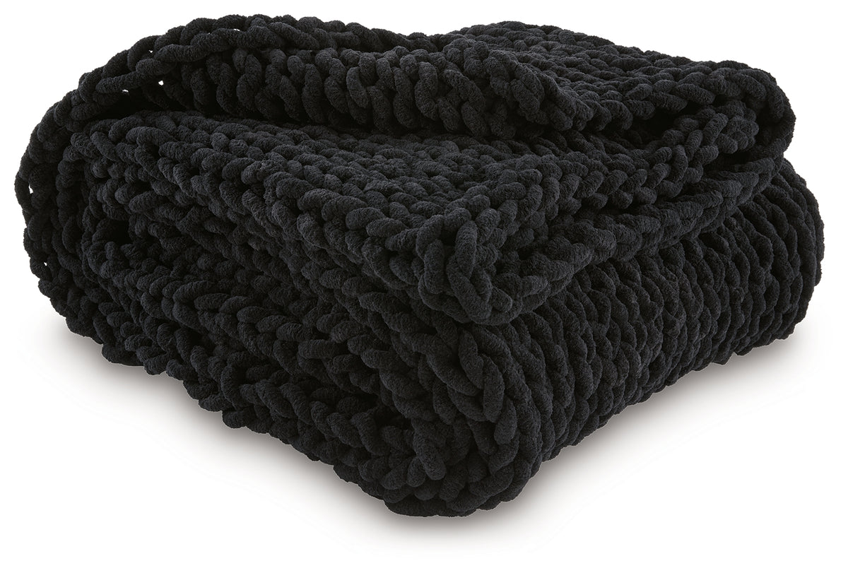 Close-up of hand-knitted texture on black chenille throw