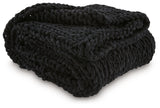 Close-up of hand-knitted texture on black chenille throw