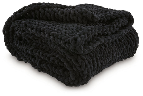 Close-up of hand-knitted texture on black chenille throw