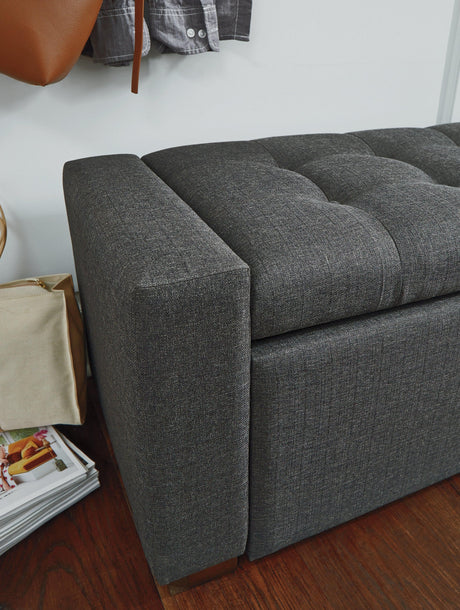 Close-up of tufted gray upholstery and wood legs
